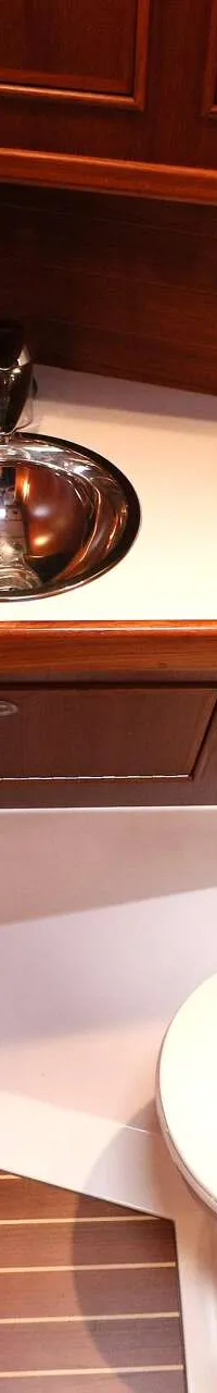 Een badkamer met houten wanden, een toilet, een wastafel met kraan en een toiletrolhouder.