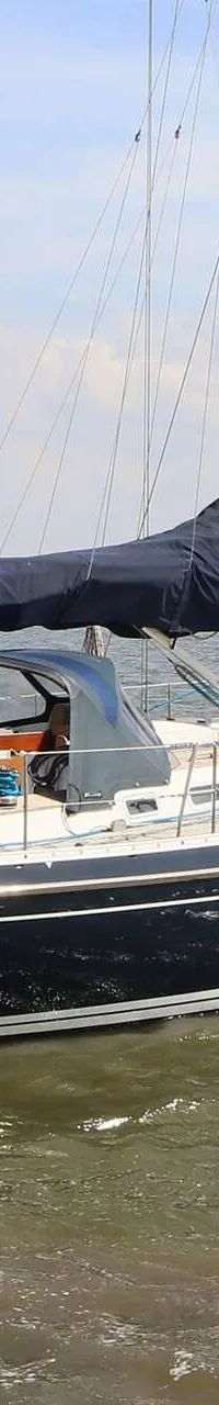 Een donkerblauwe zeilboot met een Nederlandse vlag met een "W" en kroon vaart op een meer. — Victoire 1270
