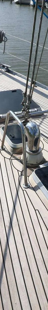Een bovenaanzicht van het teakhouten dek van een zeilboot met twee luiken, twee lieren en diverse touwen. — Victoire 1270