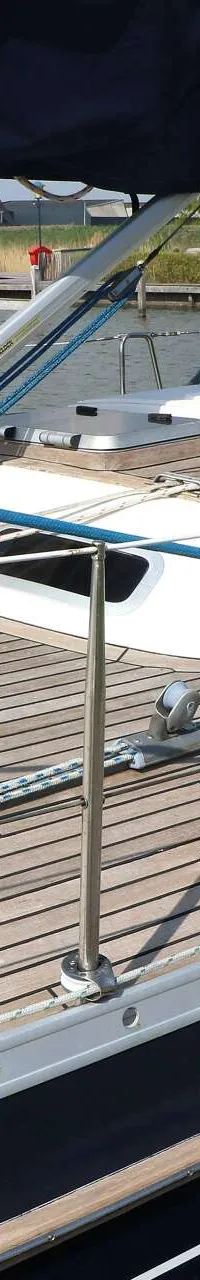 Een zeilboot met een teakdek en een donkerblauwe romp ligt afgemeerd aan een houten steiger. — Victoire 1270