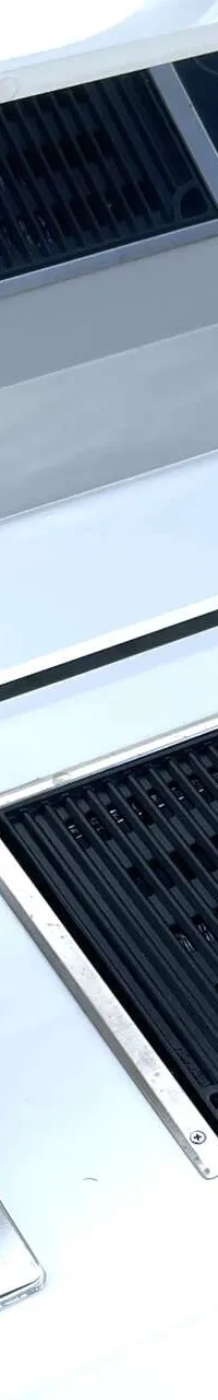 Een witte buitenkeuken met een ingebouwde grill en een roestvrijstalen spoelbak met kraan.