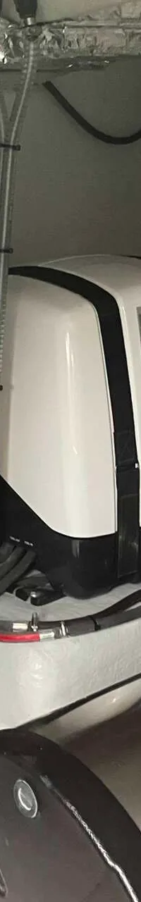 Een detailfoto van een motorruimte met diverse apparatuur, slangen en bedrading.