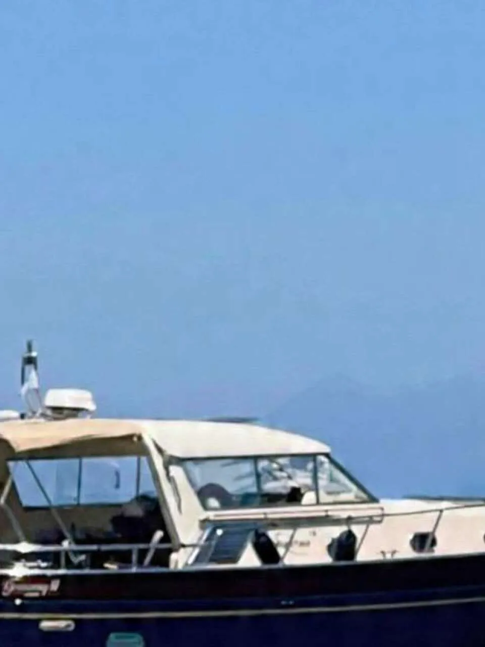 Een donkerblauwe motorboot met een beige kap en de naam "Greenray II LONDON" ligt in een jachthaven. — Apreamare 12 Cabinato