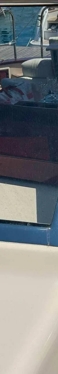 De foto toont een deel van een boot met een voorruit, vishengels en een houten dek. — Apreamare 12 Cabinato