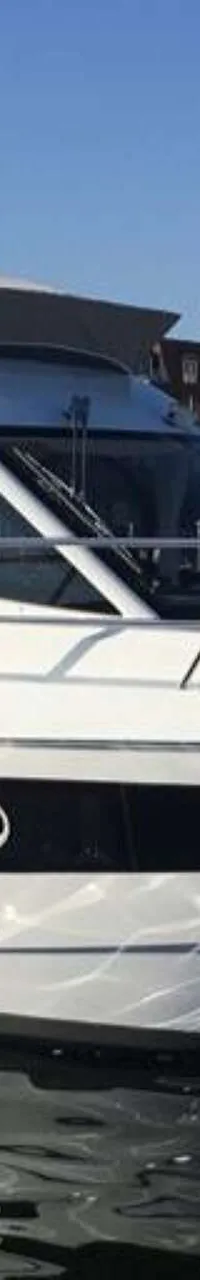Een witte motorboot met een donkere streep op de romp ligt aangemeerd aan een houten steiger. — Galeon 300 Fly