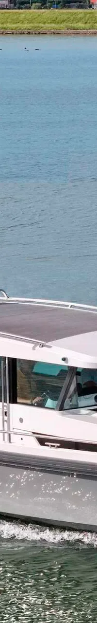 Een grijze motorboot met witte opbouw, registratie 31-19-YV en de naam SEAYOU2, vaart op blauw water. — Axopar 37 AC