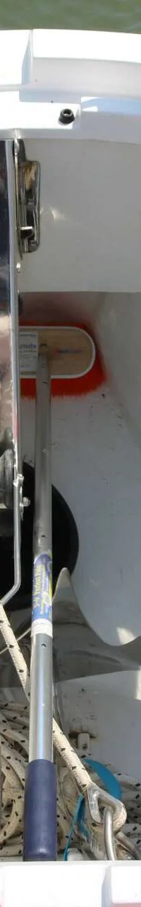 Een open wit opbergvak met een blauwe gasfles, touwen, een borstel, een ankerrol en diverse apparatuur.