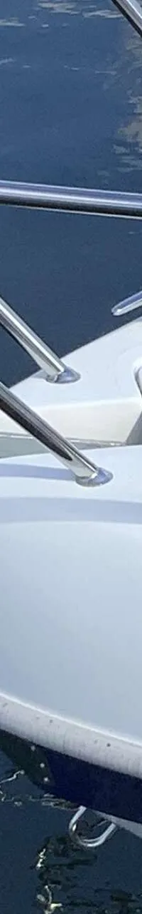 De boeg van een witte boot met een anker, reling en blauwe belettering is zichtbaar. — Saver 750 Cabin
