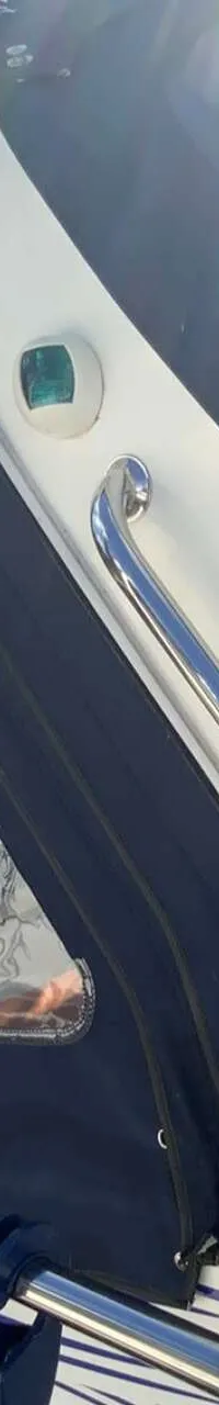 Een witte boot met een donkerblauwe cabriokap en de naam "GAVER" op de zijkant, ligt aangemeerd. — Saver 750 Cabin
