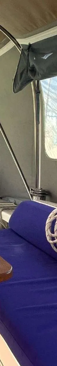 Een houten tafel, blauwe kussens, touwen en navigatieapparatuur zijn zichtbaar in de kuip van een boot. — Arcona 430