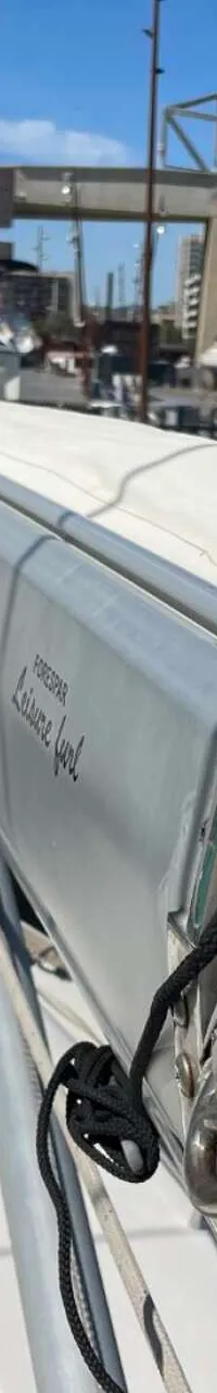 Een opgerold zeil in een grijze hoes met het opschrift "FORESPAR Leisure furl" is zichtbaar op een boot. — Arcona 430