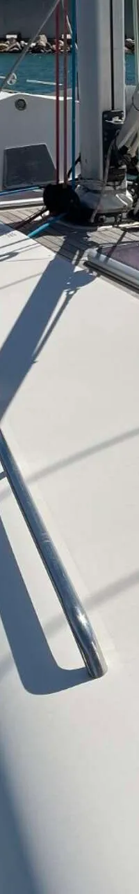 Een bovenaanzicht van het dek van een witte zeilboot met een mast, luiken, zonnepanelen en fenders. — Arcona 430