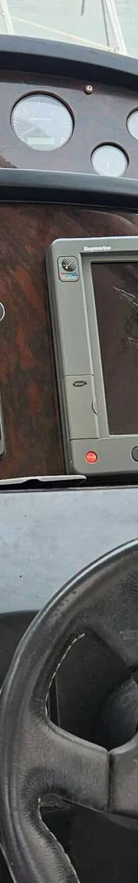 De foto toont een stuurstand met diverse meters, displays, schakelaars en een stuurwiel.