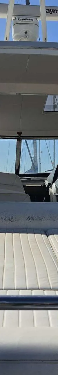 Een achteroverzicht van een boot met witte kussens en een stuurconsole zichtbaar door de voorruit. — Sunseeker Portofino 53