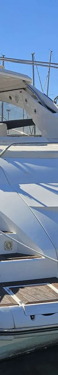 Een witte motorboot met een donkergrijze romp ligt aangemeerd, met "You Crazy Diamond" op de spiegel geschreven.