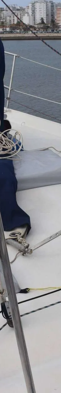 Een vooraanzicht van het dek van een zeilboot met een opgerold blauw zeil, touwen en een mast. — Endurance 44
