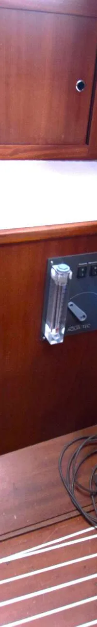 Een houten interieur met een wit aanrechtblad, een bedieningspaneel en een omvormer.