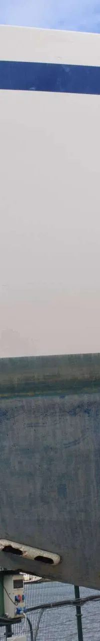 Een witte boot met een blauwe streep, de tekst "ALEA IACTA EST" en een boegschroef, staat op de wal. — Endurance 44
