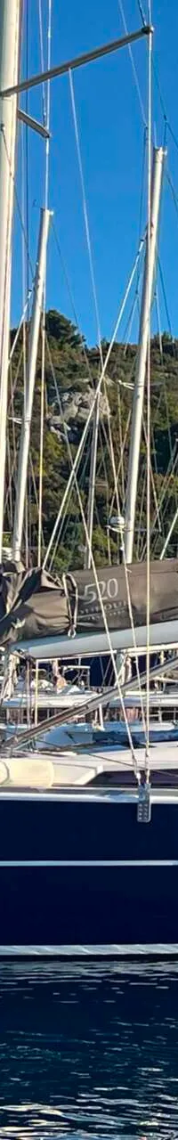 Een donkerblauwe zeilboot met de naam "NOTUS" en registratienummer "94675 RG" ligt in het water. — Dufour 520 Grand Large