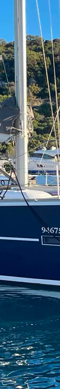 Een donkerblauwe zeilboot met de naam "NOTUS" en registratienummer "94675 RG" ligt in het water. — Dufour 520 Grand Large