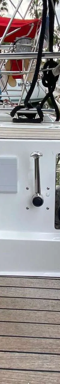 De foto toont een deel van een bootkuip met een houten vloer en een wit paneel met diverse meters en bedieningselementen.