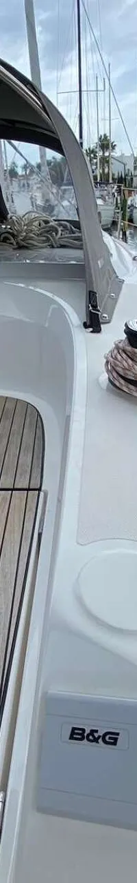 Een bovenaanzicht van het dek van een zeilboot met een teakvloer, een grijze buiskap en een B&G-paneel. — Bavaria 34 Cruiser
