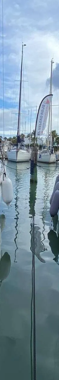 Twee zeilboten liggen afgemeerd in een haven, met een witte boot links en een donkerblauwe boot rechts. — Bavaria 34 Cruiser