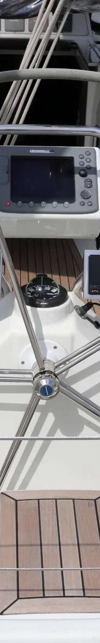 Een bovenaanzicht van de kuip van een zeilboot met een stuurwiel, navigatie-instrumenten en teakhouten dek. — Dehler 39 SQ