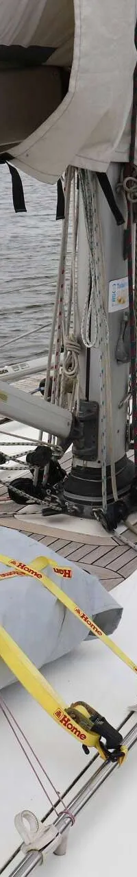 Een bovenaanzicht van een zeilboot met een zonnepaneel, mast en giek, liggend aan een steiger. — Dehler 39 SQ