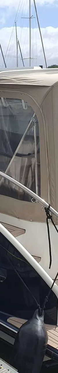 Een donkerblauwe boot met de naam "GRETHE" en "Hamburg 176172-S" op de spiegel, ligt afgemeerd aan een houten steiger.
