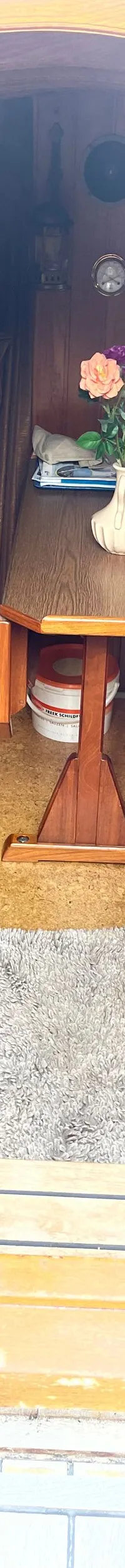 Een interieur van een boot met houten wanden, een tafel met bloemen, een toilet en een gootsteen. — Gipon Grundel 800