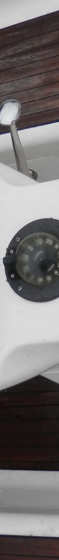 Een stuurstand met een bruin stuurwiel, twee Raytheon displays, een kompas en een gashendel is zichtbaar.