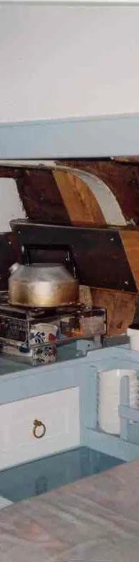 Een interieur van een boot met een kombuis, een bed en houten spanten. — Boeier Lantinga 900