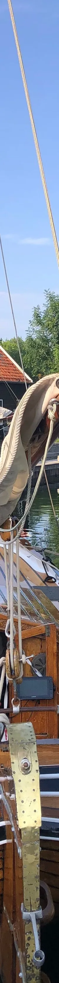 Een houten zeilboot genaamd "PLEUNTJE" ligt afgemeerd aan een houten steiger in een jachthaven. — Boeier Lantinga 900