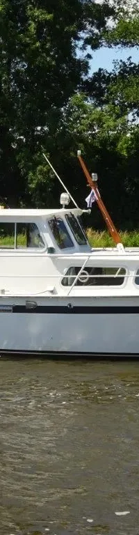 Een witte motorboot met blauwe bimini en de naam "Brandaris" op de boeg vaart op het water. — Pedro Kruiser 1000 AK