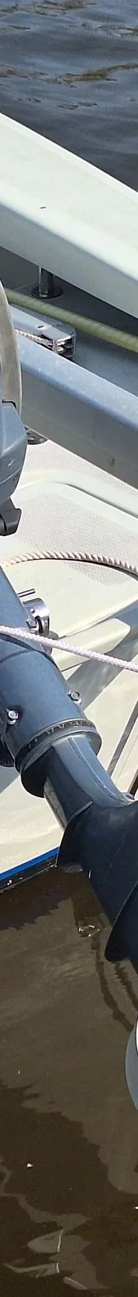 Een lichtgrijze boot met een buitenboordmotor aan de spiegel, een beschermde schroef en de naam "Randmeer" op de romp.