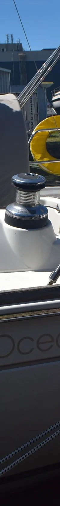 Een witte zeilboot met de naam "Oceanis 37" en "BENETEAU" is afgemeerd aan een houten steiger. — Beneteau Oceanis 37