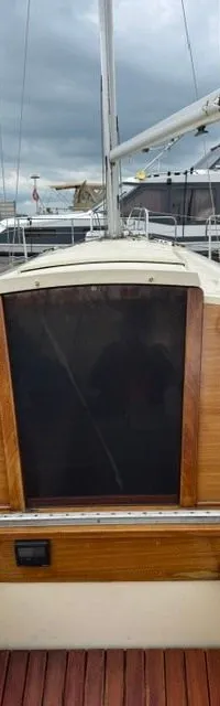 De kajuitingang van een zeilboot met houten afwerking, donkere luiken, instrumenten en touwen is zichtbaar.