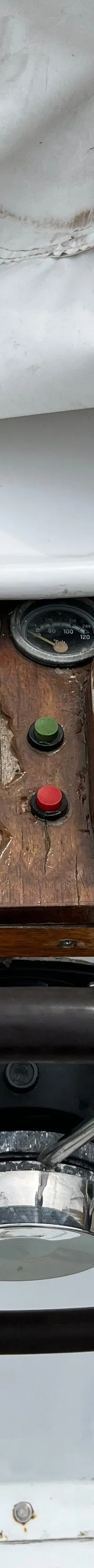 Een stuurwiel met een houten bedieningspaneel met meters, schakelaars en een gashendel is zichtbaar.