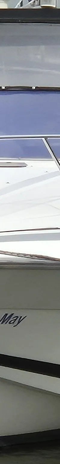 Een witte motorboot met de naam "Zian-May" ligt afgemeerd in een haven, omringd door andere boten. — Sunseeker 38 Martinique
