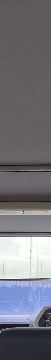 De foto toont het interieur van een boot met een grijs plafond, een stuur en een dashboard. — Sunseeker 38 Martinique
