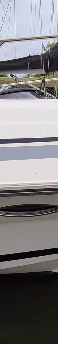 Een witte boot met blauwe ramen en een zwarte stootwil hangt aan de zijkant. — Sunseeker 38 Martinique