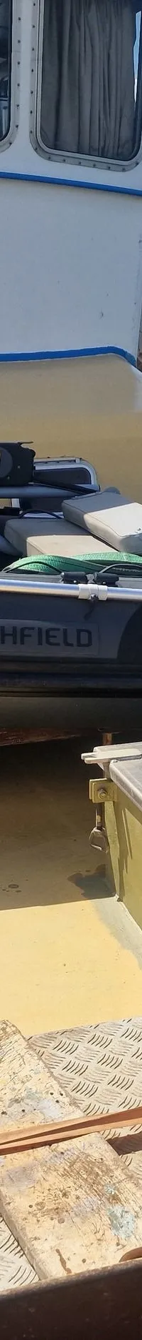 Een grijze rubberboot met een Yamaha buitenboordmotor ligt op het dek van een boot genaamd "ZEEUIL".