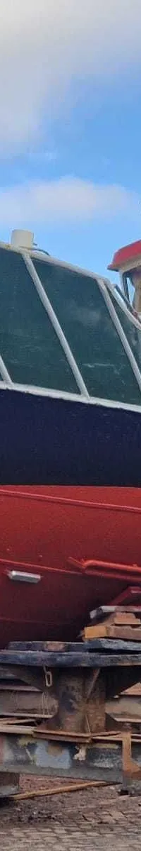 Een driekleurige boot met de naam "ZEEMEEUW" en "OL5" op de boeg staat op een scheepshelling.