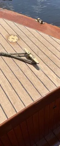 De boeg van een houten boot met een teakhouten dek en een touw dat aan een kikker is vastgemaakt. — De Jongvlet 6.20