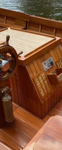Een houten boot met een stuurwiel, een kompas, een gashendel en een brandblusser in de kuip. — De Jongvlet 6.20