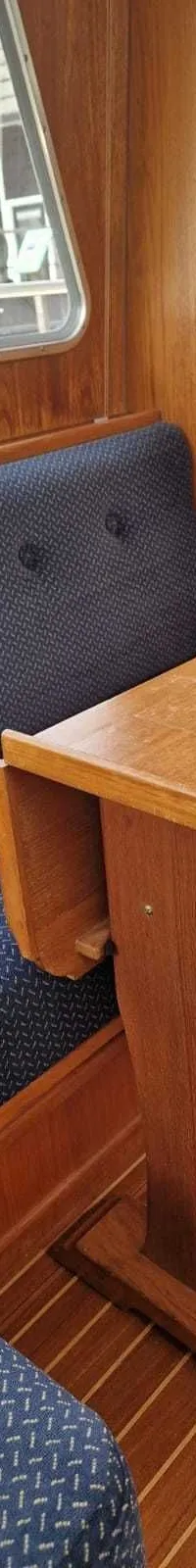 Een houten dashboard met een Dometic gashendel, Yanmar meters, schakelaars, een zekeringkastje en een informatiebordje.