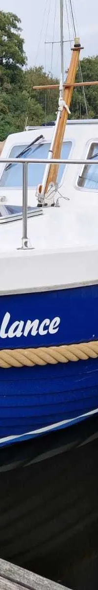 Een blauw-witte boot met de naam "Balance" ligt afgemeerd aan een houten steiger. — Drammer 8.20 Classic