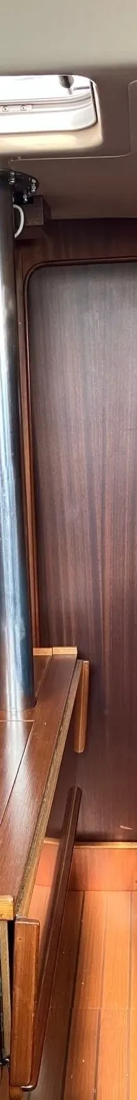 Een kombuis met een fornuis, oven, gootsteen en houten kasten.
