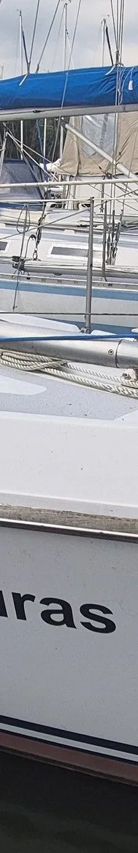 Een witte zeilboot genaamd "Turas" ligt afgemeerd in een haven met andere boten op de achtergrond. — Contest 36 Ketch